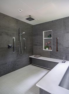 a modern bathroom with gray walls and white flooring, including a large bathtub