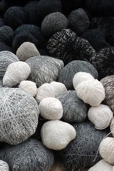 several balls of yarn are piled on top of each other in black and white colors