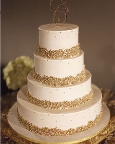 a white and gold wedding cake on a table