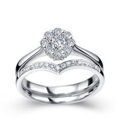 a heart shaped diamond ring on top of a white gold band with diamonds in the middle