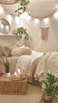 a white bedroom with plants and lights on the ceiling