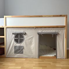 a bunk bed with two doors open on the top and bottom side, in a room with hardwood floors