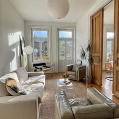 a living room filled with furniture and lots of windows