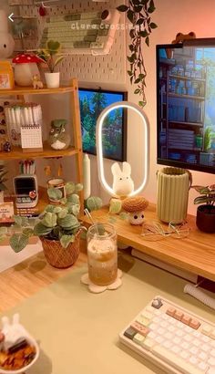 a desk with a computer monitor, keyboard and mouse on it next to a potted plant