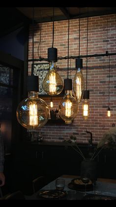 the light bulbs are hanging from the brick wall