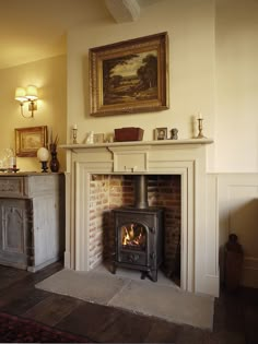 a living room with a fire place next to a painting on the wall above it