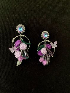 Flower cluster earrings, purple and green flower earrings with crystal and resin flowers: the earrings are made up of a cluster of small resin flowers and leaves, in shades of green, purple, parma. The cluster is decorated with small drops of amethyst purple and very pale pink crystal. The whole thing is mounted on a silver circle decorated with a small parma butterfly, then on a nail decorated with a "vitrail light" crystal cabochon with purple and sky blue reflections. The buckles are mounted on rods and the pusher is provided. They measure 5cm in length x 2.5cm at the widest point All my jewelry is packaged with care, and delivered in tracked parcel or international tracking. I communicate the tracking number as soon as the package is sent. Purple Flower Earrings For Party, Green Flower Earrings, Light Crystal, Flower Cluster, Earrings Purple, Silver Circle, Amethyst Purple, Resin Flowers, Purple And Green