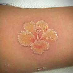 a close up of a person's arm with a flower tattoo on the side