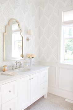 a white bathroom with two sinks and mirrors