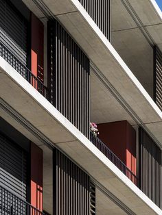 an apartment building with balconies and red shutters