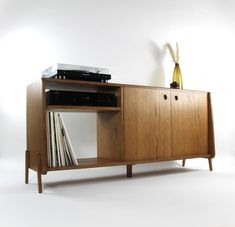 an entertainment center with record players and records on it's sideboard, against a white background