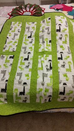 a green and white quilt with animals on it