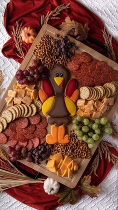 a turkey shaped cookie sitting on top of a wooden tray filled with cheese and crackers