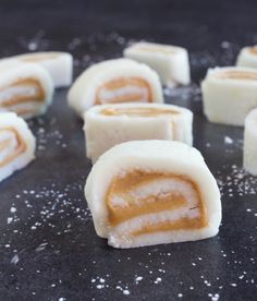 several pieces of food sitting on top of a black counter covered in powdered sugar