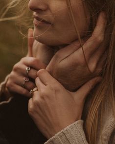 a close up of a person holding their hand near her neck and looking off into the distance