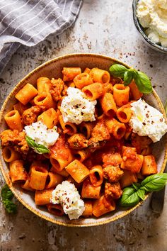 a bowl filled with pasta and cheese on top of a table