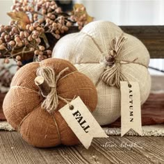 three pumpkins sitting on top of a wooden table next to some burlocks