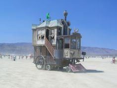 an unusual looking building sitting on top of a sandy beach