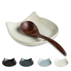 a wooden spoon sitting on top of a white plate next to three different colored bowls