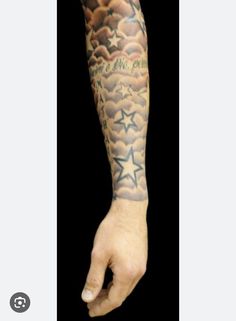 a person with a tattoo on their arm and hand is holding something in the air