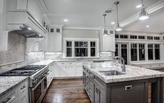 a large kitchen with white cabinets and marble counter tops