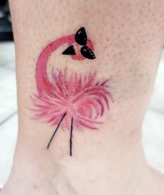 a pink flamingo tattoo on the side of a woman's foot with black dots