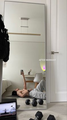 a man laying on the floor in front of a mirror