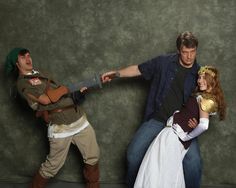 three people dressed up in costumes posing for a photo with one person holding a knife