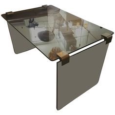 a glass table with metal legs and a wooden base