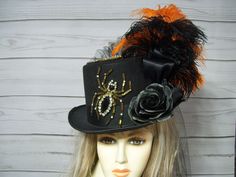 Ladies Black top hat with two large beaded and rhinestone spiders with black roses, black and orange ostrich feathers and a black bustle and train on the back. This is a black hard felt costume grade top hat. PLEASE MEASURE YOUR HEAD! This hat is 22.5" for the inside circumference. I will include a peel and stick hat sizer if you need it smaller, but I cannot make it larger. Please keep this in mind when deciding. Check out my other items in my shop. Thank you for stopping by. All sales are final! Please keep that in mind when purchasing. Check out my other hats and fascinators.  https://www.etsy.com/shop/MsPurdy I ship many times a week. This hat will ship priority mail within the U.S. with tracking number. Black Top Hat For Costume, Fitted Black Top Hat For Costume, Black Fitted Top Hat For Costume, Fitted Costume Hats And Headpieces For Halloween, Fitted Costume Hats And Headpieces For Halloween Themed Events, Fitted Black Top Hat With Feathers, Fitted Top Hat For Halloween Costume, Black Steampunk Costume Accessories For Themed Events, High Crown Halloween Costume Accessories For Costume Party