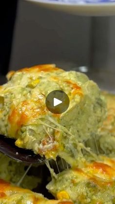 a spoon full of guacamole sitting on top of a pan filled with food