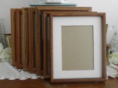 three frames sitting next to each other on top of a wooden table with lace doily