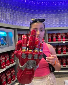 a woman holding up a giant iron man glove