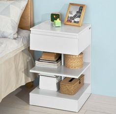 a small white shelf with baskets on it and a picture frame sitting on top of it