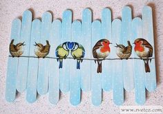 four birds are sitting on the clothes pegs and one is painted blue with white dots