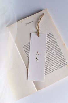 two bookmarks with flowers on them are laying next to each other