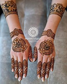 two hands with henna tattoos on them