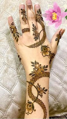 a woman's hand with henna tattoos on it