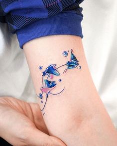 a woman's arm with two dolphins on it