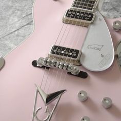 a pink electric guitar sitting on top of a table