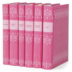 the pink books are lined up against each other on a white background with an ornate border