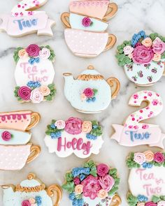 decorated cookies with tea cups and flowers on a marble countertop for a bridal party