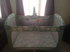 a baby crib sitting in front of a window