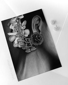 a black and white photo of a pair of earring's next to a card