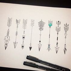 some black pens are sitting on top of a piece of paper with arrows drawn on it