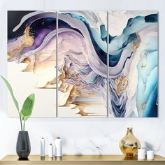 three abstract paintings on a wall above a table with vases and plant in it