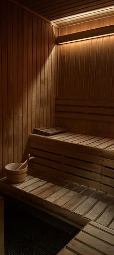 an empty sauna with wooden benches and lights