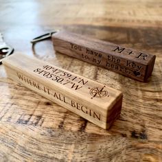 two personalized wooden bottle openers sitting on top of a table next to each other