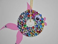 an ornament made to look like a bird with multicolored glass beads