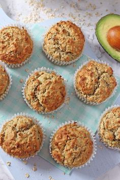 muffins on a tray with an avocado next to it and some other food